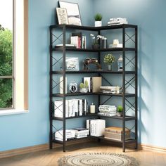 a room with blue walls and a black book shelf filled with books on top of it