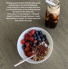 a bowl of cereal with berries and yogurt next to a jar of liquid