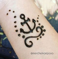 an anchor tattoo on someone's arm with drops of water coming out of it