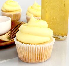 cupcakes with frosting and butter on a plate next to honey dipper