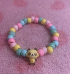 a bracelet with a small yellow and pink beaded animal on it's side