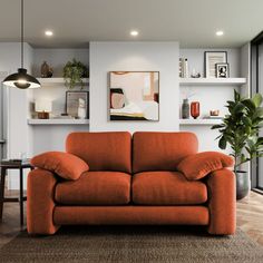 an orange couch sitting in the middle of a living room