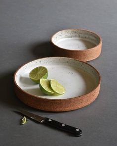 two plates with limes on them next to a knife