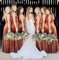 a group of women standing next to each other in front of a white tent with flowers