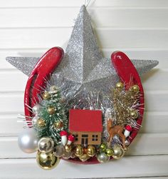 a christmas wreath hanging on the side of a wall with ornaments and decorations around it