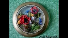 there is a glass and metal frame with flowers in it on the wall above a green tablecloth