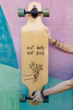 a person holding up a skateboard with writing on it