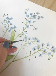 someone is painting flowers with watercolors on paper