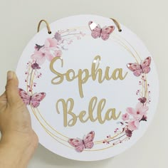 a person holding up a sign with butterflies on it that says sophha bela