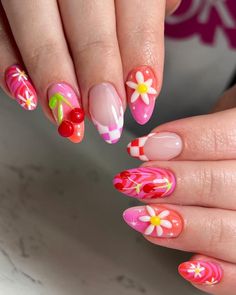 a woman's hand with pink and white flowers on it, holding onto her nails