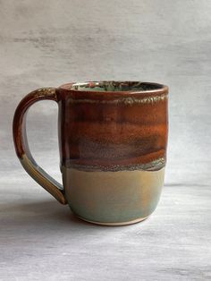 a brown and green coffee cup sitting on top of a table