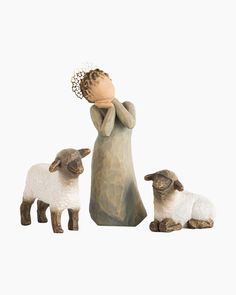 a figurine of a woman and two lambs with a flower in her hair