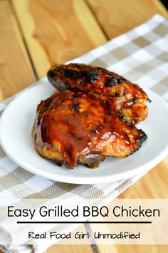 two grilled bbq chicken on a white plate with a checkered table cloth