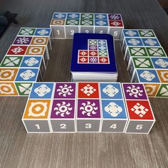 several colorful tiles are arranged in the shape of a square, with numbers and symbols on them