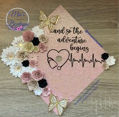 a pink graduation cap with flowers and butterflies on the side that says, and so the adventure begins