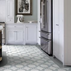 a kitchen with white cabinets and gray flooring