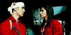 the man and woman are dressed up in red outfits, one is wearing a bandana