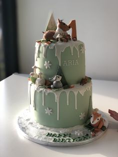 two tiered cake with frosting and animals on top