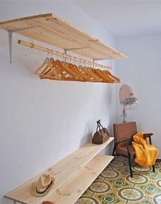 a room with a bench, chair and hat on the shelf next to a wall