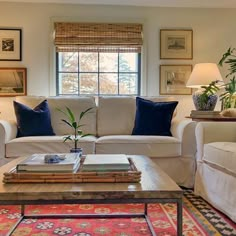 a living room with couches, tables and pictures on the wall in it's windowsill