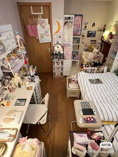 a room filled with lots of clutter next to a bed and desk in front of a window