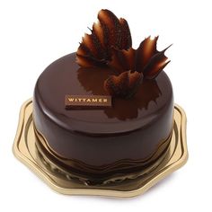 a chocolate cake sitting on top of three gold plates