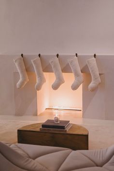 stockings hanging from the ceiling in front of a fire place with a book on it