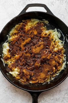 an iron skillet filled with pasta and meat