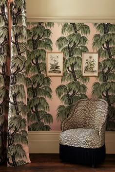 a leopard print chair in front of a wall with palm trees on it and curtains