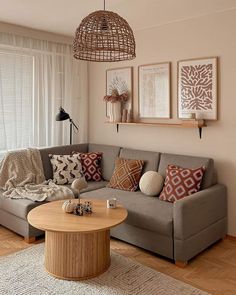 a living room with a couch, coffee table and two pictures on the wall above it