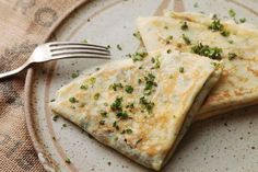 two quesadillas on a plate with a fork