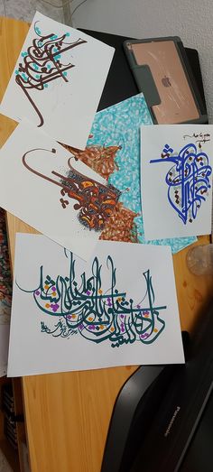 several arabic calligraphys are displayed on a desk