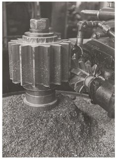 an old black and white photo of a machine with gears on it's side