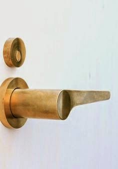 an old brass door handle on a white wall