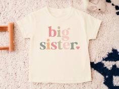 Big Sister T Shirt, Big Sis T Shirt, Big Sister Shirt, Big Sister To Be, Pregnancy Announcement Shirt, Baby Announcement Shirt, Sister Shirt 💗  Welcome to The WildflowerbyMiley Etsy Shop!  This listing is for the bodysuit, sweatshirt or t-shirt only. All other items that are shown in our photos such as shoes, hats, beanies, blankets etc. are for photo staging purposes and are NOT INCLUDED in the sale. DESCRIPTION:  This baby and children's unisex essential fits like a well-loved favorite. Super soft t-shirts, sweatshirts and baby bodysuits for your little lads and gals meant to showcase their big personalities. Its Excellent quality and vibrant print makes one fall in love with it over and over again.  This adorable piece is the perfect lightweight layer for casual wearing.  This product Diy Big Sister Shirt, I’m Going To Be A Big Sister Announcement, Im A Big Sister Shirt, Big Sister Finally Shirt, Big Sister T Shirt, Big Sister Applique Shirt, I’m Going To Be A Big Sister Tshirts, Baby Announcement Shirts, Big Sis