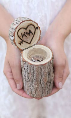 someone holding a piece of wood that has been carved into the shape of a heart