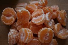 peeled oranges sitting on top of a wooden table