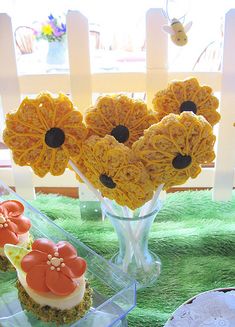 three vases filled with yellow flowers on top of a green carpeted tablecloth