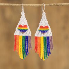 two pairs of beaded earrings hanging from a tree branch