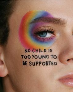 a woman's face with the words no child is too young to be supported painted on her cheek