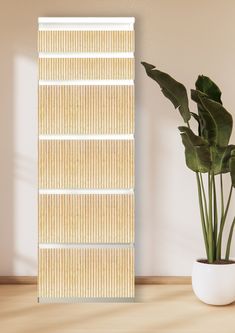 a potted plant sitting next to a tall bamboo screen on top of a wooden table