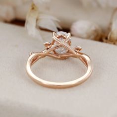 a close up view of a ring on a white cloth with flowers in the background