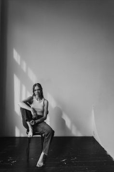 a black and white photo of a woman sitting on a chair