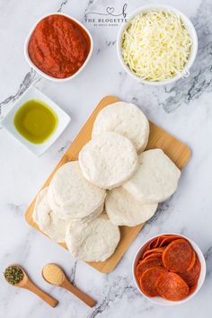 the ingredients to make homemade pizza are laid out on a cutting board and ready to be eaten