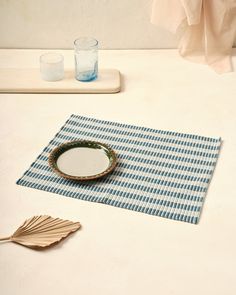 a blue and white checkered placemat next to two empty glasses