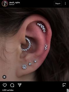 a woman's ear with three different piercings