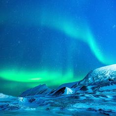 the northern lights shine brightly in the sky above snow covered mountains