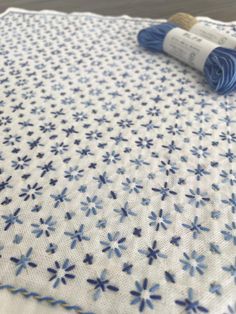 two skeins of yarn sitting on top of a white and blue quilting