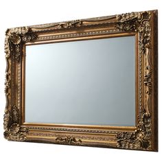 an ornate gold framed mirror on a white wall