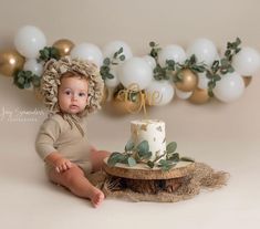 a baby sitting in front of a cake